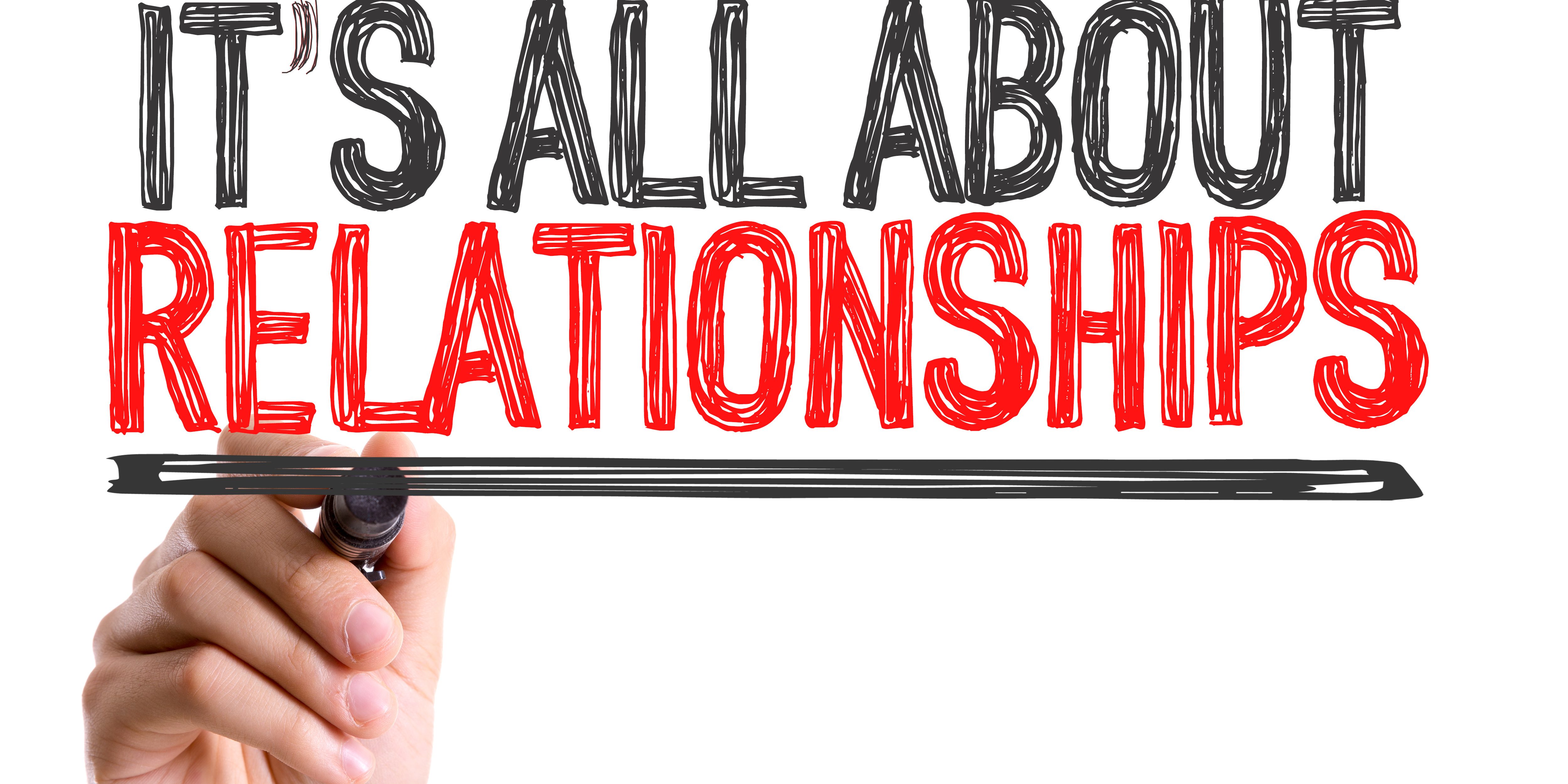 Hand with marker writing the word Its All About Relationships