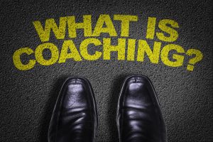 Top View of Business Shoes on the floor with the text: What Is Coaching?