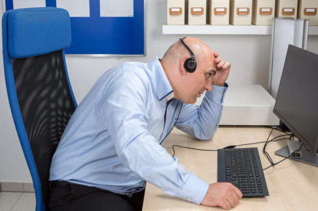 Frustrierter Call Center Mitarbeiter verzweifelt am Kunden